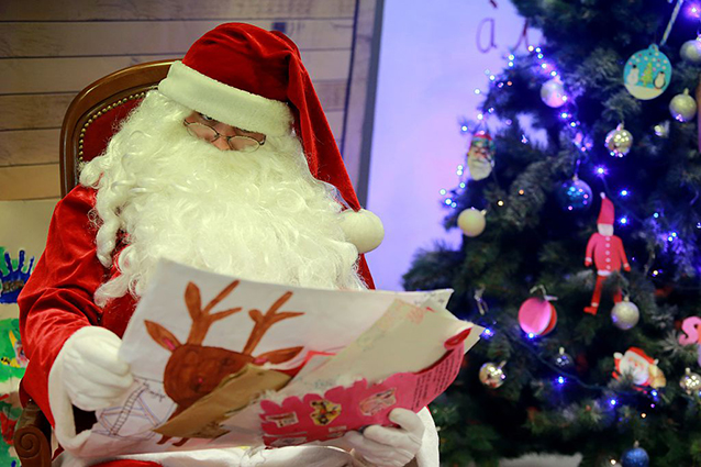 A man dressed as Santa Claus reads Christmas letters sent by children at the Libourne's post office, southwestern France, on December 18, 2015.
A special unit of La Poste, which opened in 1962, employs each year around 60 people to answer letters by children from 140 countries.  / AFP / NICOLAS TUCAT        (Photo credit should read NICOLAS TUCAT/AFP/Getty Images)