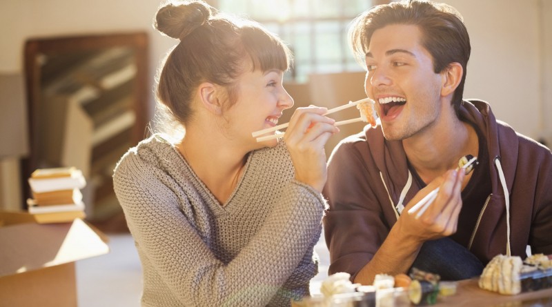 Couple eating sushi together in new home